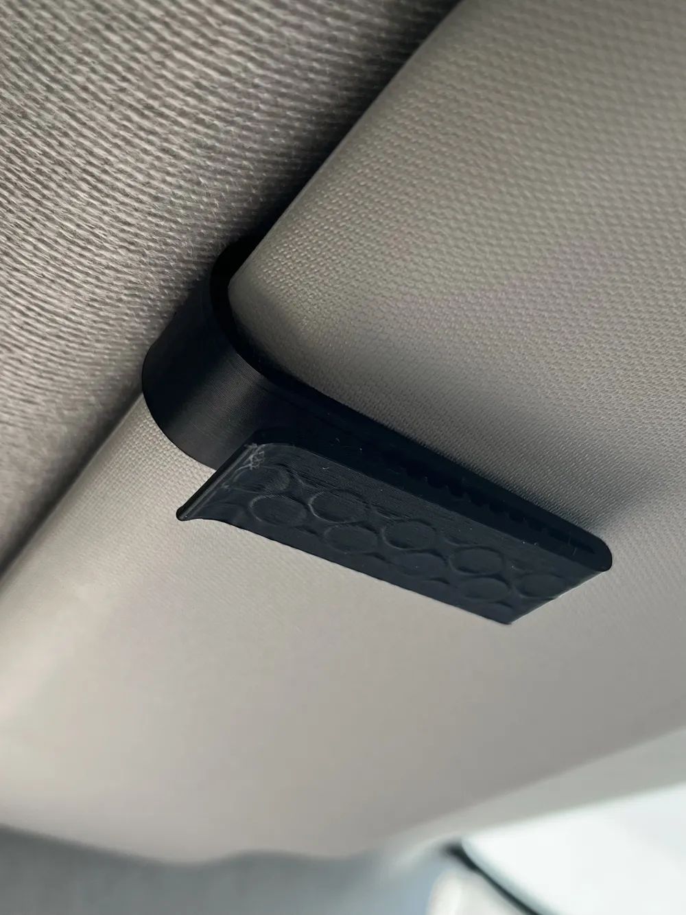 Soporte para gafas de sol en la visera del coche